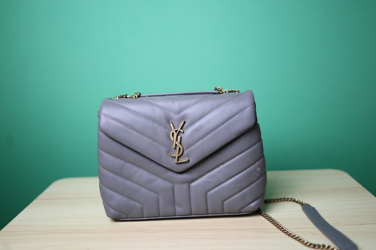 Bolsa acolchoada cinza com fivela dourada em formato de letra