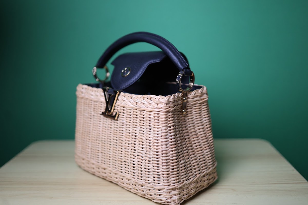 Bolsa bucket em palha natural trancada, alca de couro e fecho de giro dourado