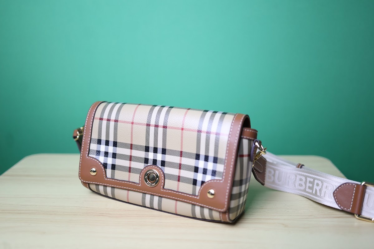 Bolsa pequena marrom em couro com monograma e fecho redondo dourado