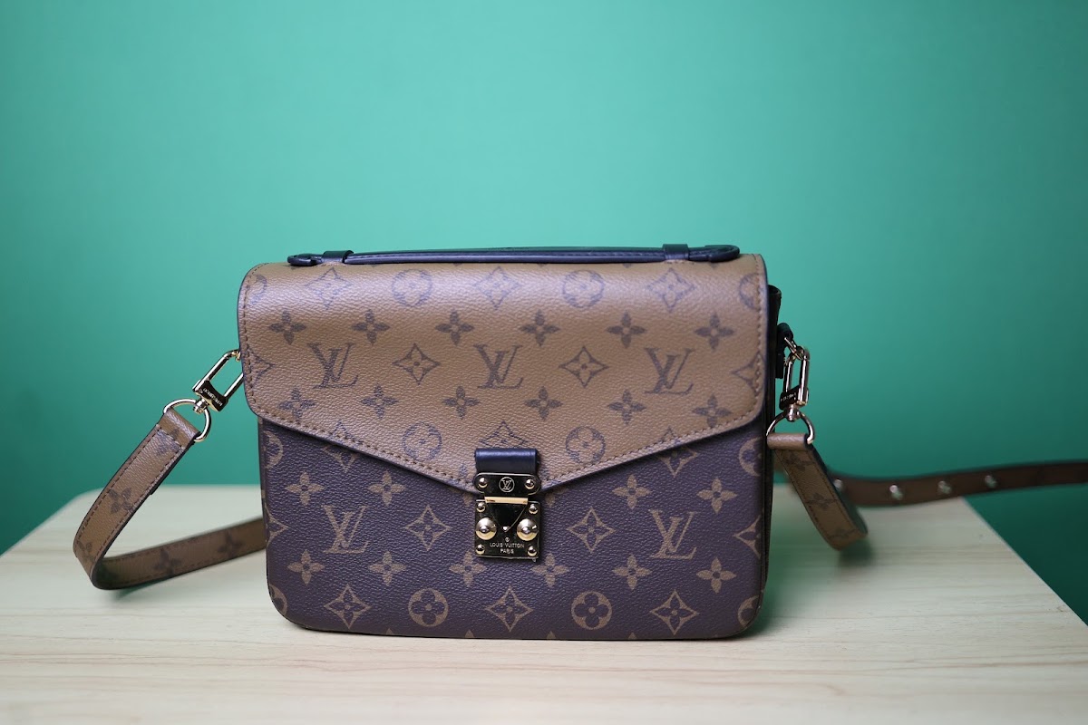 Bolsa pequena marrom em couro com monograma e fecho prateado